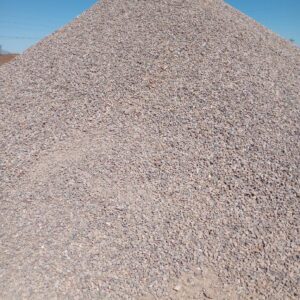 Large pile of gravel under clear sky.